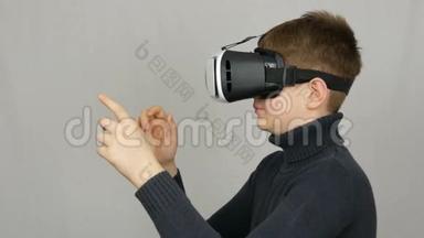 青少年男孩看白色虚拟现实眼镜或虚拟现实，并在工作室的白色背景上玩得很开心。 未来是